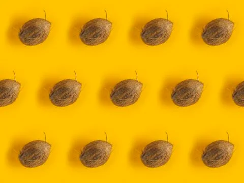 Pattern with ripe coconuts on yellow background. Top View. Copy Space. Pop ar Foto stock