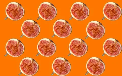 A pattern of ripe figs cut in half on an orange background. Stock Photos