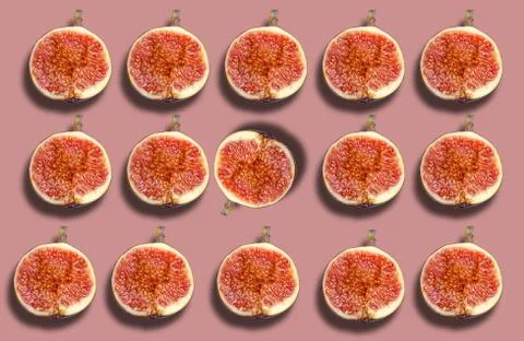A pattern of ripe figs cut in half on a colored background. Stock-Fotos