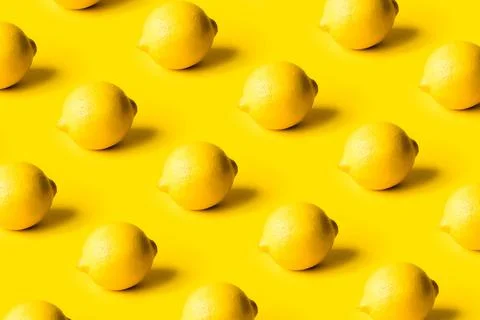 Pattern of ripe lemons on a yellow background. Stock Photos