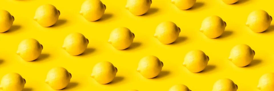 Pattern of ripe lemons on a yellow background. Stock Photos