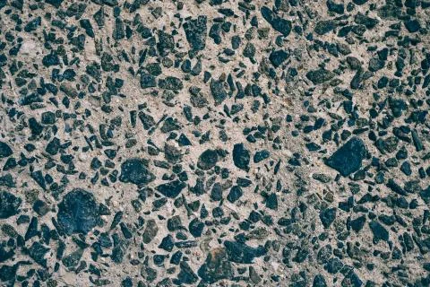 Pattern - Road gray coating of cement and dark grey gravel stones. Stock Photos