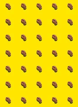 A pattern of roasted coffee beans on a yellow background. Coffee pattern. Foto stock