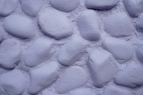 A pattern of rounded smooth purple-painted stones embedded in cement 写真素材