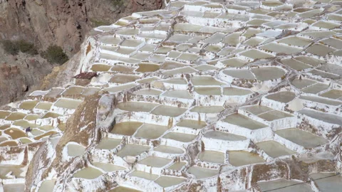 Pattern of salt terraces with salt workers in salt pans at Salinas de Maras Stock Footage 202289792