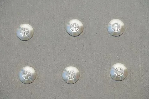 Pattern of silver discs on a concrete wall surface Stock Photos