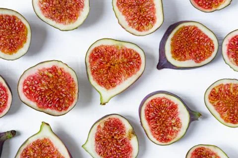 Pattern of sliced figs on a white background. Close-up photo of chopped figs. Stock Photos