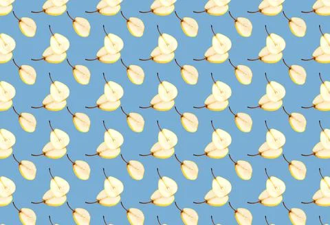A pattern with slices of fresh pear cut in half on a blue background. Fruit Stock Photos