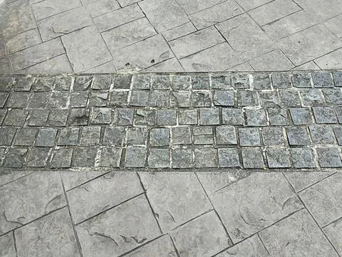 Pattern of small stone blocks on a cement walkway Stock Photos