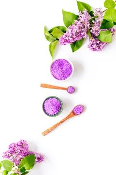Pattern of spa sea salt in spoons with lilac flowers. Above view Stock Photos