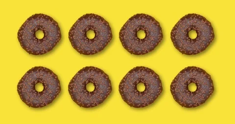 Pattern with spinning chocolate donuts. Creative food concept, top view Stock Footage 128923104