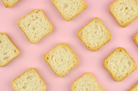 Pattern of square bread croutons on a pink background, top view Foto stock