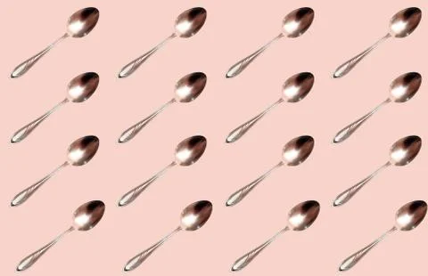 Pattern with a steel spoon on a beige background. Foto stock