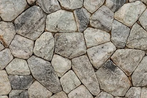 Pattern of stone from gray multi-faceted and uneven background solid Stock Photos