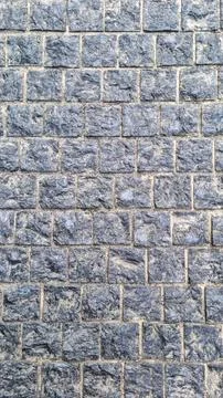 Pattern of stone pavement made of square blue-grey granite blocks Stock Photos
