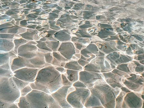 Pattern of a sunshine through the rippling water surface Stock Photos