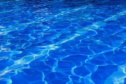 Pattern in swimming pool background. Beautiful Blue pool reflecting the sun r Stock Photos