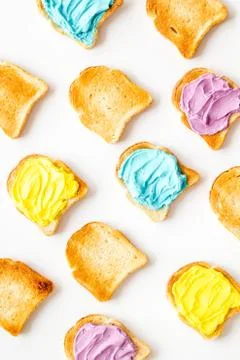 Pattern of toast bread with colored cheese spread. Layout top view Stock Photos