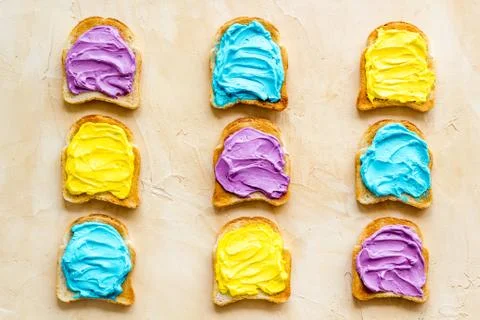 Pattern of toast bread with colored cheese spread. Layout top view Stock Photos