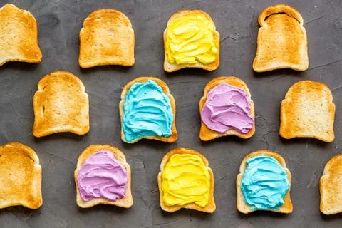Pattern of toast bread with colored cheese spread. Layout top view Stock Photos