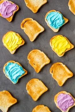 Pattern of toast bread with colored cheese spread. Layout top view Stock Photos