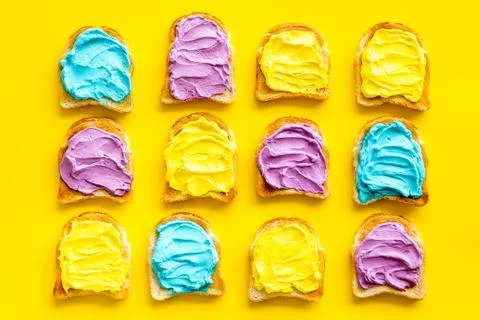 Pattern of toast bread with colored cheese spread. Layout top view Stock Photos