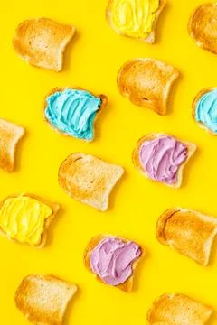 Pattern of toast bread with colored cheese spread. Layout top view Stock Photos