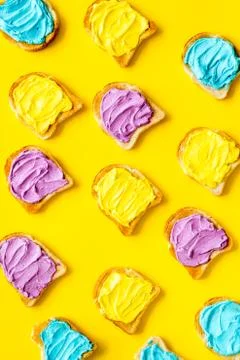 Pattern of toast bread with colored cheese spread. Layout top view Stock Photos
