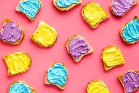 Pattern of toast bread with colored cheese spread. Layout top view Stock Photos