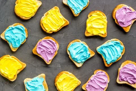 Pattern of toast bread with colored cheese spread. Layout top view Stock Photos