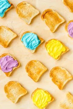 Pattern of toast bread with colored cheese spread. Layout top view Stock Photos