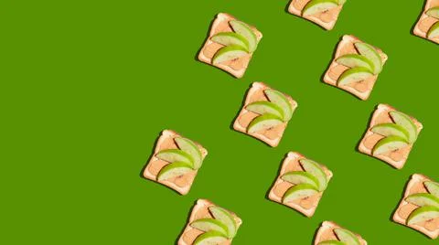 Pattern of toasted bread with apple and cinnamon on green background. Stock Photos
