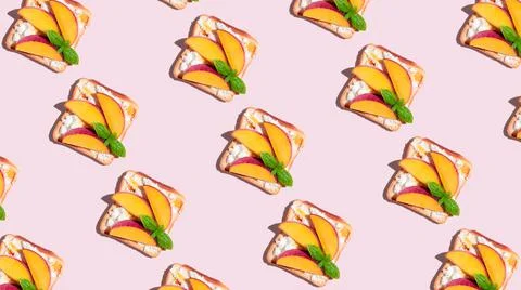 Pattern of toasted bread with peach and basil on pink background. Stock Photos