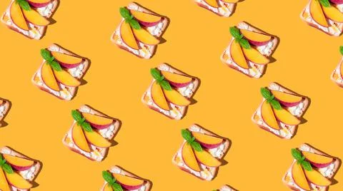 Pattern of toasted bread with peach and basil on yellow background. Stock Photos
