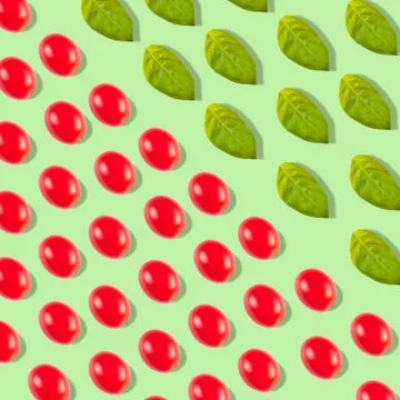Pattern with tomato cherry and basil leaves on a green background Stock Photos