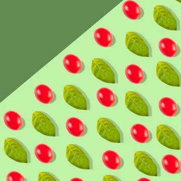 Pattern with tomato cherry and basil leaves on a green background Stock Photos