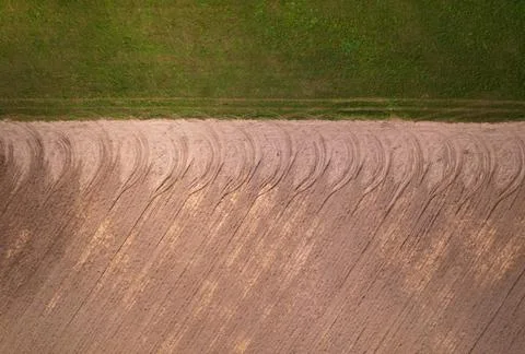Pattern of tread marks from tractor wheels on farmland. Stock Photos