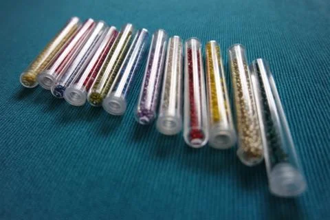 Pattern of tubes with small beads in a row blue background Stock Photos