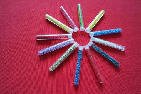 Pattern of tubes with small beads sun red background Stock Photos