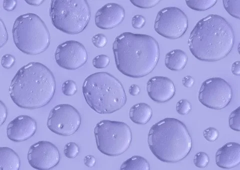 Pattern of violet colored doses of gel or serum on monochrome background Stock Photos