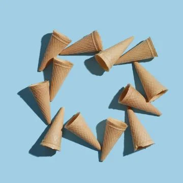 The pattern of wafer ice cream cones empty with shadows on a pastel blue paper Foto stock