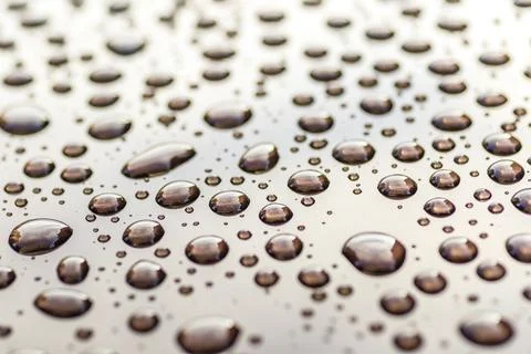 Pattern of water drops in a shining metallic surface with sky reflections,Wat Foto stock