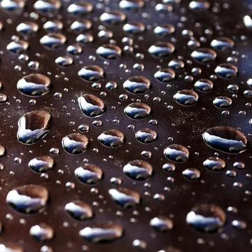 Pattern of water drops in a shining metallic surface with sky reflections,Wat Foto stock