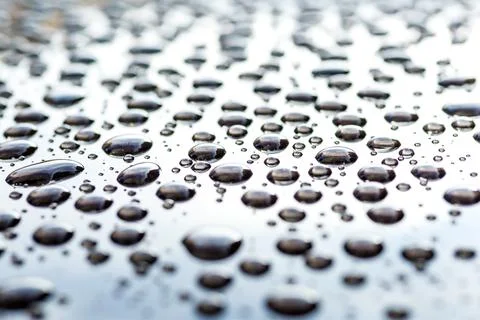 Pattern of water drops in a shining metallic surface with sky reflections,Wat Stock Photos