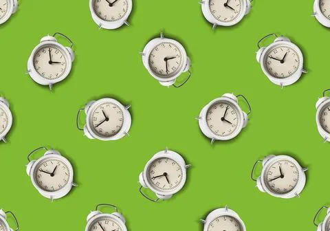 Pattern of white alarm clocks on light green background Foto stock
