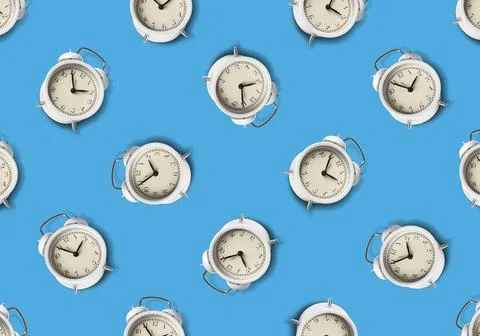 Pattern of white alarm clocks on pale blue background Foto stock