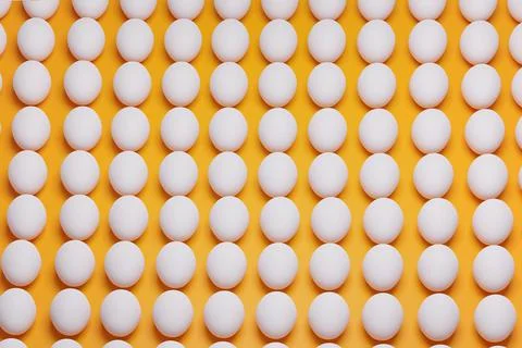Pattern from white chicken eggs on yellow background top view. Creative food Stock Photos