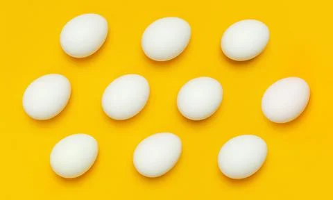 Pattern from White chicken eggs on yellow background top view flat lay Stock Photos