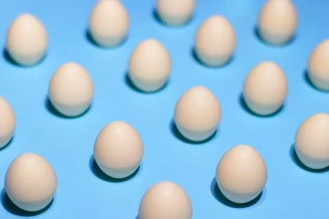 The pattern of white chocolate eggs on a blue background Stock Photos