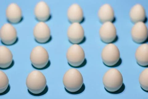 Pattern of white chocolate eggs on a blue Stock Photos